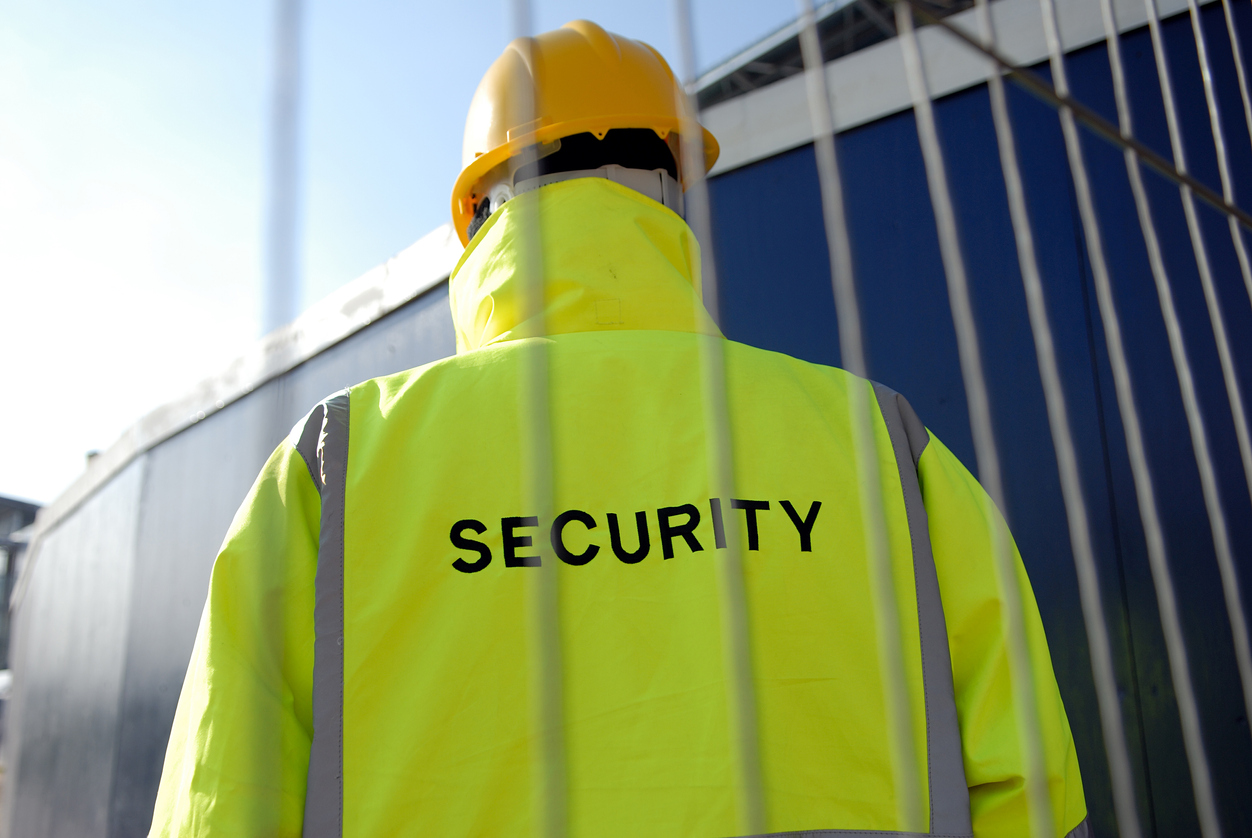 View of security man from behind on a construction site