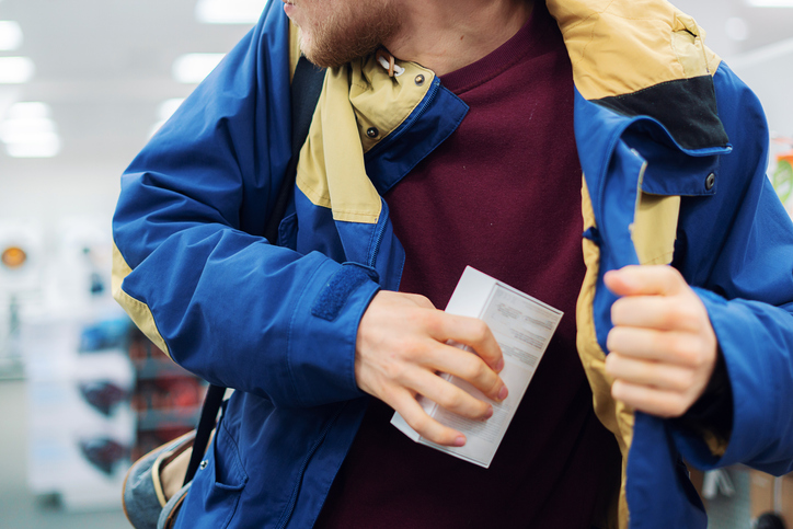 close up consumer throwing his hands putting the new gadget in the pocket in the store